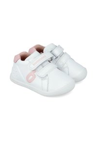 Zapatillas de piel blanca con detalles en rosa y dos correas de Velcro. Punta redondeada y suela de goma texturizada. Marca en el lateral en rosa.