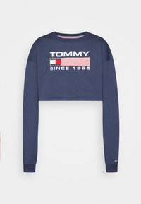 Sudadera corta azul marino hecha de algodón, con texto gráfico blanco y de colores "TOMMY JEANS SINCE 1985" y rayas. Mangas largas.