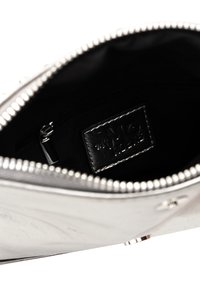 Borsa a sacchetto argento con una superficie liscia, foderata in tessuto nero e dotata di una tasca interna. Etichetta visibile all'interno con dettagli testurizzati.