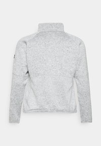 Pulôver cinza de fleece com gola alta, costuras laterais e mangas longas. Apresenta uma textura suave e um design minimalista. Sem acessórios ou detalhes.