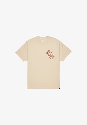 Beige bomull t-skjorte med grafisk design av røde terninger på venstre bryst. Klassisk rund hals og korte ermer. Glatt tekstur.