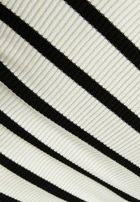 Tissu à rayures noires et blanches avec une texture côtelée. Des rayures horizontales de couleurs alternées créent un motif texturé.