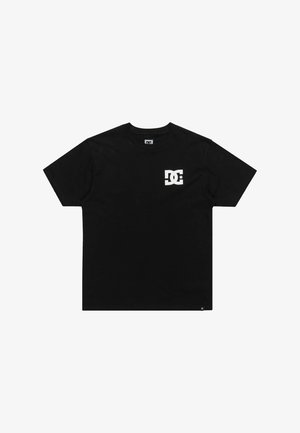 T-shirt noir à manches courtes en coton avec un logo DC blanc sur la poitrine gauche. Design classique à col rond, texture douce.