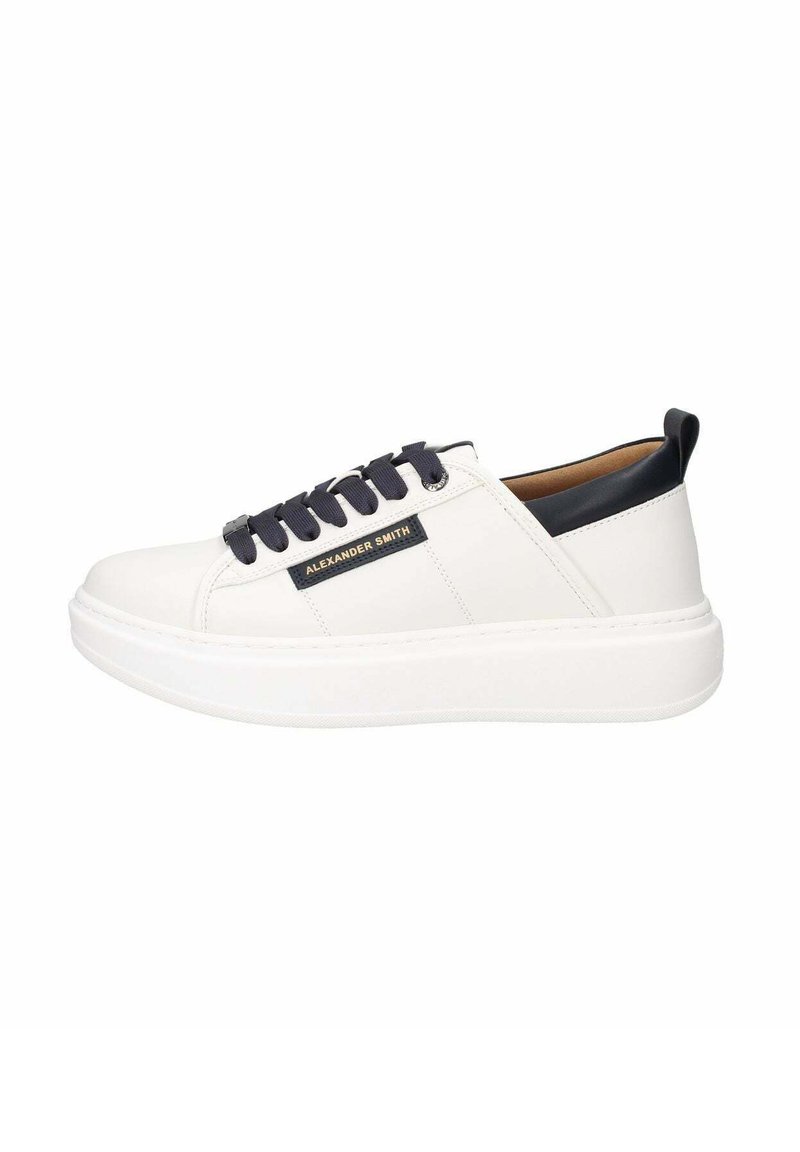 Zapatilla de cuero blanco con acentos en azul marino, que cuenta con una suela texturizada, puntera redondeada, cordones planos y una placa con el logo en el lateral.