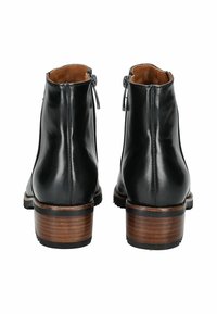 Botines de cuero negro hasta el tobillo con puntera redondeada, cremalleras laterales y un tacón de madera apilado. Textura suave y detalle de costura simple.
