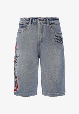 Light blue denim shorts featuring a dragon design in red, yellow, and black on the left leg, with embroidered logo on the front.