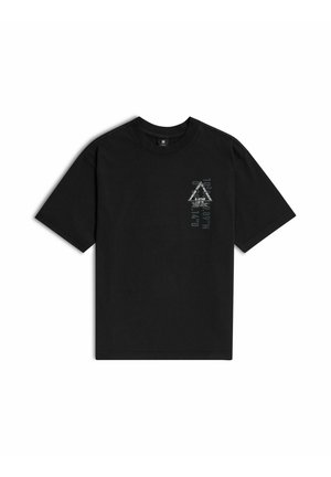 T-shirt noir à manches courtes avec un petit motif triangulaire gris et blanc et un texte sur la partie supérieure gauche de la poitrine.