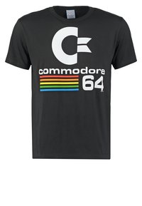 Camiseta de algodón negra que presenta un gran logo blanco con la letra "C", el texto "commodore 64" en blanco y franjas horizontales de colores del arcoíris debajo del logo.