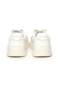 Sneaker bianchi in pelle con finitura liscia, forma arrotondata e branding sottile. Presentano una semplice allacciatura e una suola imbottita.