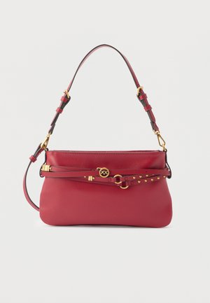 Sac à main en cuir rouge avec bandoulière réglable, logo à boucle dorée et détail de ceinture cloutée décorative enroulée autour du devant.