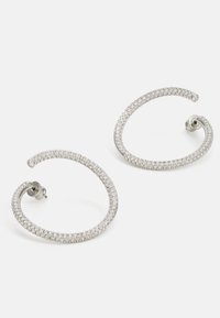 Boucles d'oreilles en argent en forme de croissant, ornées de strass transparents le long du bord extérieur, mettant en valeur une texture lisse.