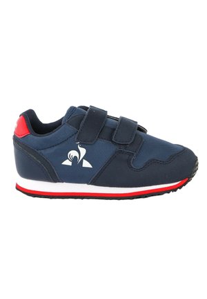 Zapatilla azul marino con detalles en negro y rojo, dos tiras de velcro, logo blanco en el lateral, y detalle rojo en el talón y borde de la suela.