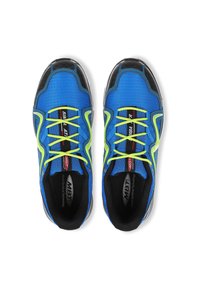 Baskets de sport bleu avec des accents noirs, des lacets jaunes et une tige texturée. Présente un logo et un intérieur rembourré. Design léger.