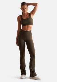 Top court côtelé olive et leggings taille haute assortis. Les deux présentent un design ajusté avec un tissu texturé et des détails de couture subtils.