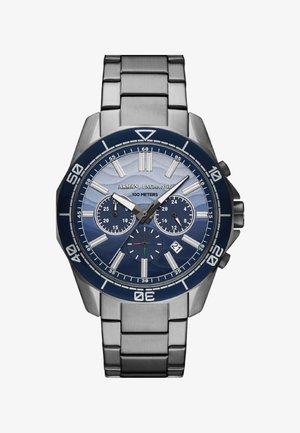 Nehrđajući čelik ručni sat s plavim bezelom, gradijentnim plavim brojčanikom, tri podbrojčanika i srebrnim detaljima. Ima prozor za datum na 6 sati.