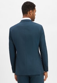Teal colbert met een textuurstof, notch-lapels en een enkele split aan de achterkant. Het colbert heeft knoopsluiting bij de mouwen en een getailleerde pasvorm.