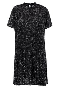 Vestido negro con mangas cortas, con un cuello alto y motas blancas. La tela es plisada, creando textura y volumen en el dobladillo.