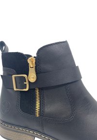 Bottines en cuir noir avec une fermeture éclair dorée, une sangle à boucle, un panneau en tissu texturé et une semelle cousue avec un léger talon.