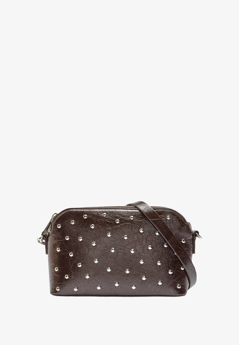 Brązowa torebka crossbody z materiału imitującego skórę, zdobiona srebrnymi ćwiekami, z suwakiem i dopasowanym regulowanym paskiem. Kompaktowy prostokątny kształt.