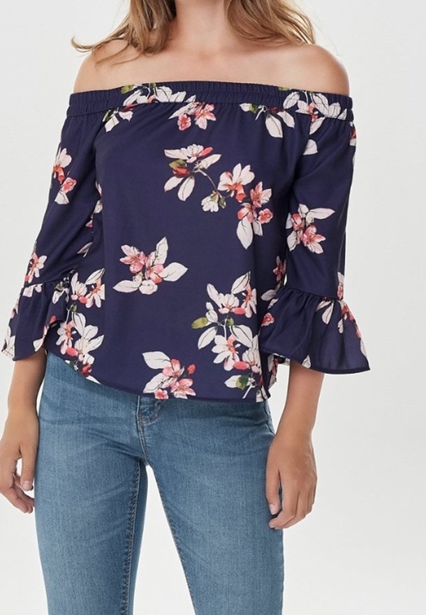 Laiva sininen avonainen blousee, jossa on kukkakuosi, levenevät hihat ja elastinen kaula-aukko. Yhdistetty farkkujen kanssa.