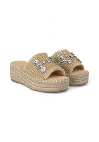 Sandales mules tissées beiges avec un talon épais tressé et des strass décoratifs sur la sangle. Semelle douce avec des accents de couture.