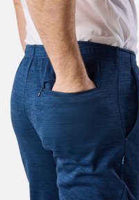 Marineblaue Sporthosen aus strukturiertem Stoff mit einer Reißverschlusstasche auf der rechten Seite für sicheren Stauraum.