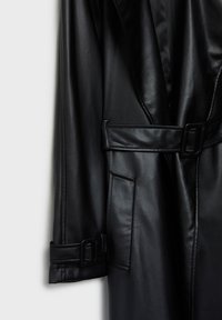 Cappotto di pelle nera con vita aderente grazie a una cintura, caratterizzato da un ampio colletto, tasca laterale e texture liscia; design minimalista.