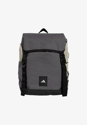 Gray and cream backpack with a flap closure, adjustable straps, and a prominent black Adidas logo. Made from durable fabric with a textured finish.