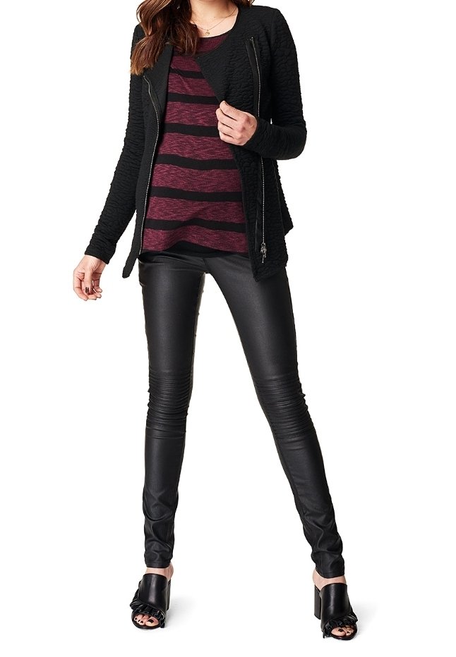 Chaqueta negra acolchada con cierre de cremallera, combinada con una camisa a rayas burdeos. Pantalones de cuero negros ajustados y sandalias negras de tacón alto.