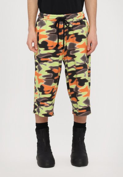 Pantaloni a bermuda con motivo mimetico in tessuti verde brillante, arancione e nero, con vita elasticizzata e cordoncino, che arrivano sotto il ginocchio.