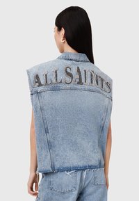 Jeans prsluk bez rukava u svijetloplavoj boji, s izgužvanim rubom i s riječi "ALLSAINTS" ispisanom kristalima na leđima.