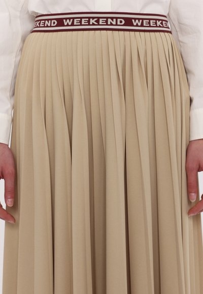 Jupe plissée beige avec une taille élastique bordeaux arborant des inscriptions répétées "WEEKEND", texture lisse et silhouette fluide.