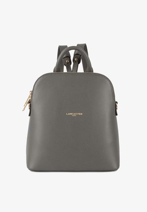 Zaino in pelle grigia rifinita con due manici superiori, spallacci regolabili, accessori in oro e dettaglio logo frontale.