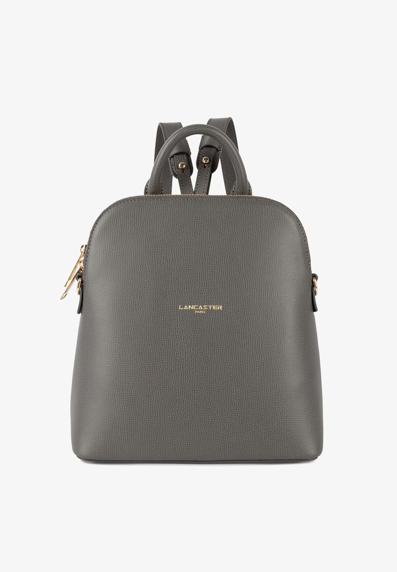 Zaino in pelle grigia rifinita con due manici superiori, spallacci regolabili, accessori in oro e dettaglio logo frontale.