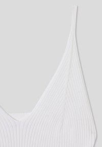 Top bianco a costine con scollatura a V profonda e spalline sottili, realizzato in un morbido tessuto elasticizzato.
