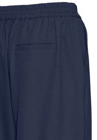 Pantalon bleu marine avec une ceinture élastique, doté de deux poches arrière et d'une texture de tissu lisse et légère.