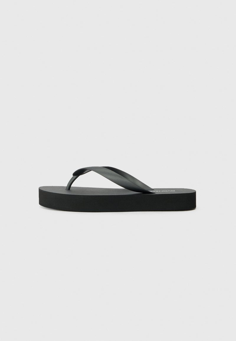 Black flip-flop featuring a flat rubber sole and thin strap design. The upper strap is slightly curved, giving a minimalist appearance.