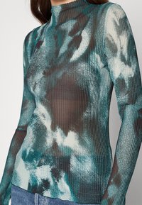 Long-sleeve top in lightweight, ribbed fabric; features a teal and dark green abstract pattern with a high neckline.