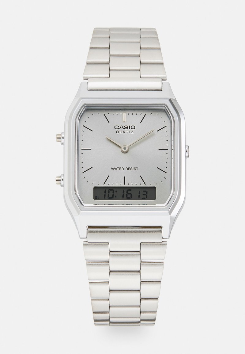 Montre à quartz Casio argentée avec un cadran rectangulaire, affichages analogiques et numériques, bracelet en acier inoxydable et caractéristiques de résistance à l'eau.