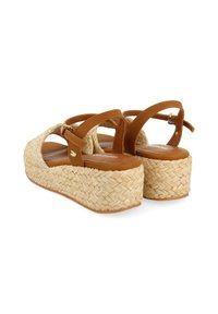 Sandalias de tiras de cuero marrón con plataforma de yute trenzado, punta redonda, talón abierto y cierre de hebilla en el tobillo. Acabado en material texturizado y natural.