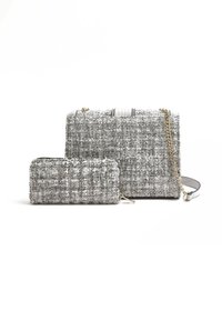 Texturerad ljusgrå tweedhandväska med guldkedjestrap, som har en randig topp och en matchande liten dragkedjeficka.