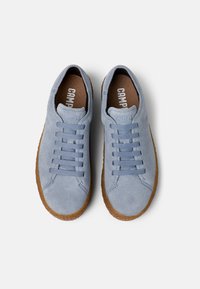 Sneakers in suede blu cielo con sei occhielli per i lacci e una suola in cuoio marrone testurizzato. L'interno presenta una stampa del logo su una soletta color carne.