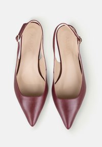 Pantofi slingback din piele bordeaux, cu vârful ascuțit, părți laterale deschise și branț bej. Au o cataramă aurie pe brățara pentru gleznă.
