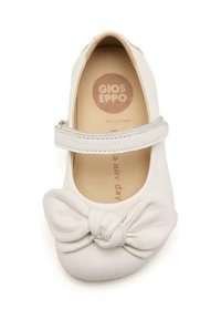 Scarpa in pelle bianca con punta arrotondata, suola piatta e un fiocco decorativo sul davanti. Presenta una cintura sopra il collo del piede.