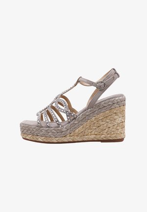 Sandalia cuña con tiras de ante gris, adornada con strass transparentes y una plataforma de yute trenzado. Presenta un cierre de hebilla y un diseño de parte trasera abierta.