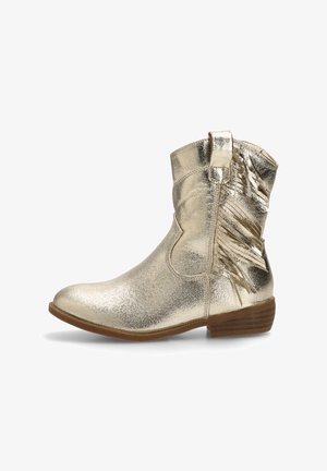 Bota de tobillo metálica dorada con un acabado suave, detalles de flecos en el costado, punta redondeada y tacón apilado marrón.