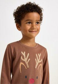 Ruskea pitkähihaisessa paidassa on poron kuvitus, jossa on kimaltavat sarvet ja punainen nenä. Paita on valmistettu pehmeästä, tekstuurista kankaasta.