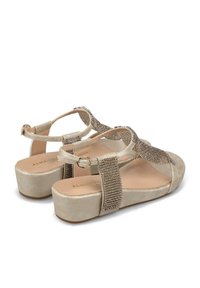 Sandali platform beige con cinturino regolabile, arricchiti da accenti metallici e un materiale superiore testurizzato, con una suola liscia.