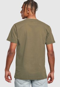 Oliven grøn bomuld t-shirt med rund hals og korte ærmer, i en afslappet pasform og med glat tekstur.
