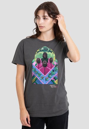 Graues Baumwoll-T-Shirt mit einem bunten Grafikdruck von Charakteren aus Squid Game, versehen mit einem geometrischen Hintergrund und dem Text "SQUID GAME 2".
